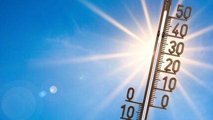 Zon met blauwe lucht en temperatuurmeter met 30+ graden